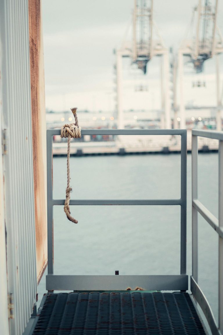 Narrow balcony on crane against modern container cranes in industrial port in daylight